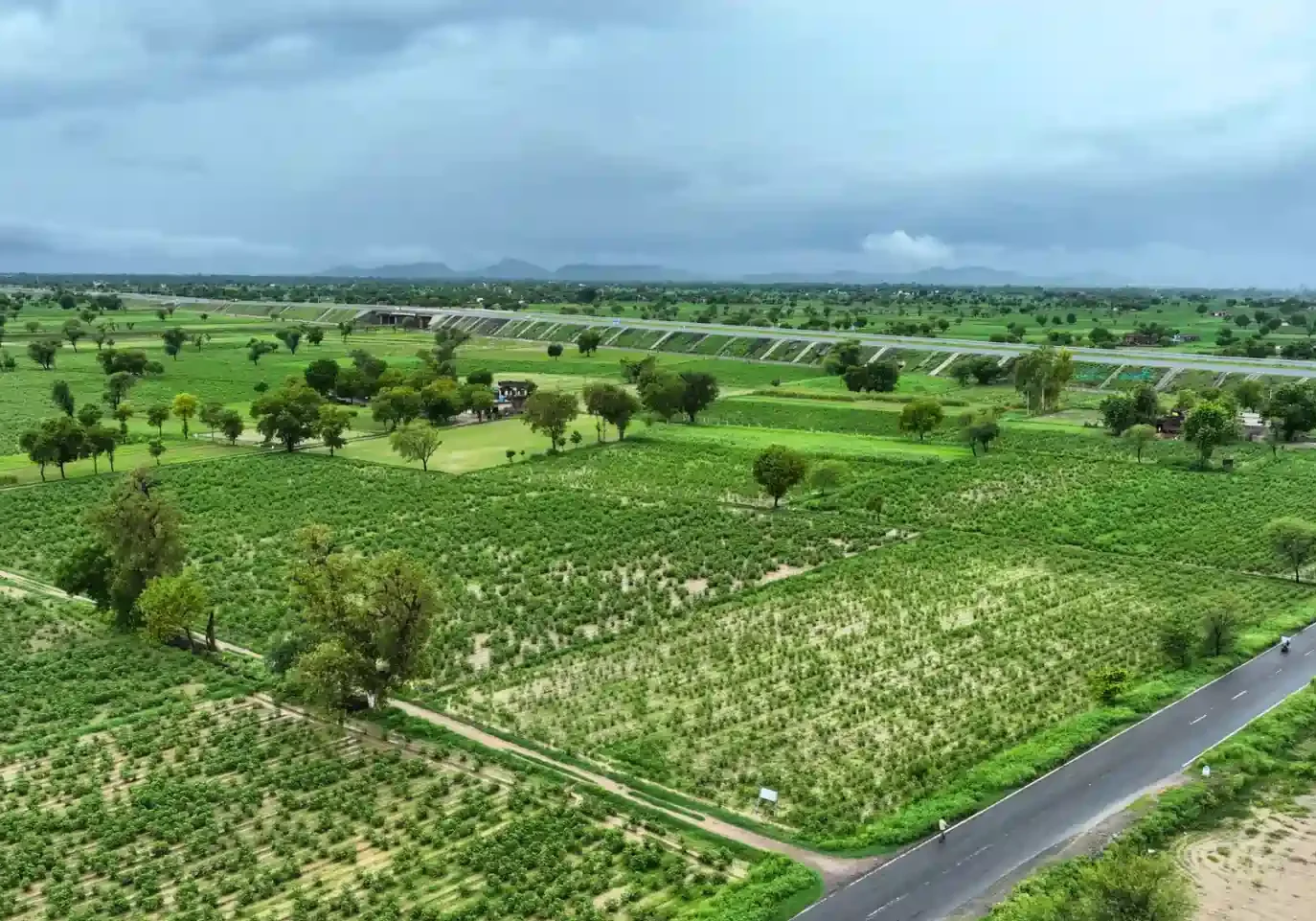 Lutyenz Living Farms with colonial-style structures set in a green rural landscape, combining elegance and eco-living.